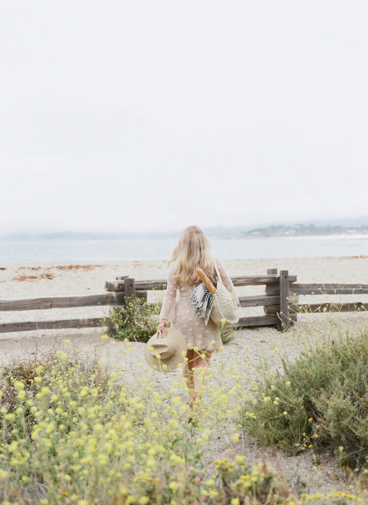 a woman walking through the beach alone