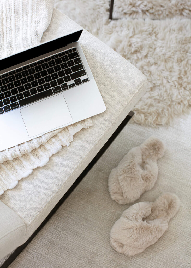 fuzzy slippers next to laptop