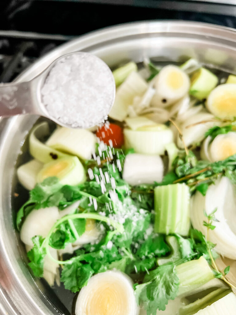 pouring salt into the vegetable stock