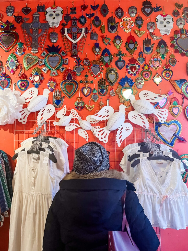 isabel looking at wall display inside thrift store